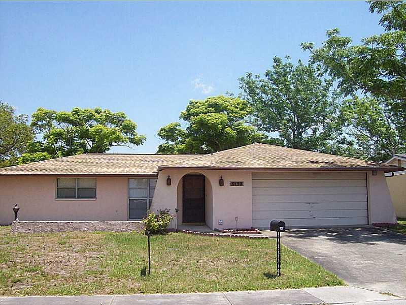9130 Chantilly Lane Port Richey, FL 34668 - Photo 1 of 1 a front view of a house with garden