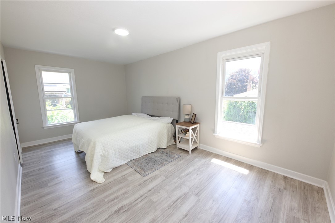 416 5th Street Chester, WV 26034 - Photo 12 of 24 Spacious room featuring wood-finish flooring, two windows with white trim, and a ceiling-mounted light fixture