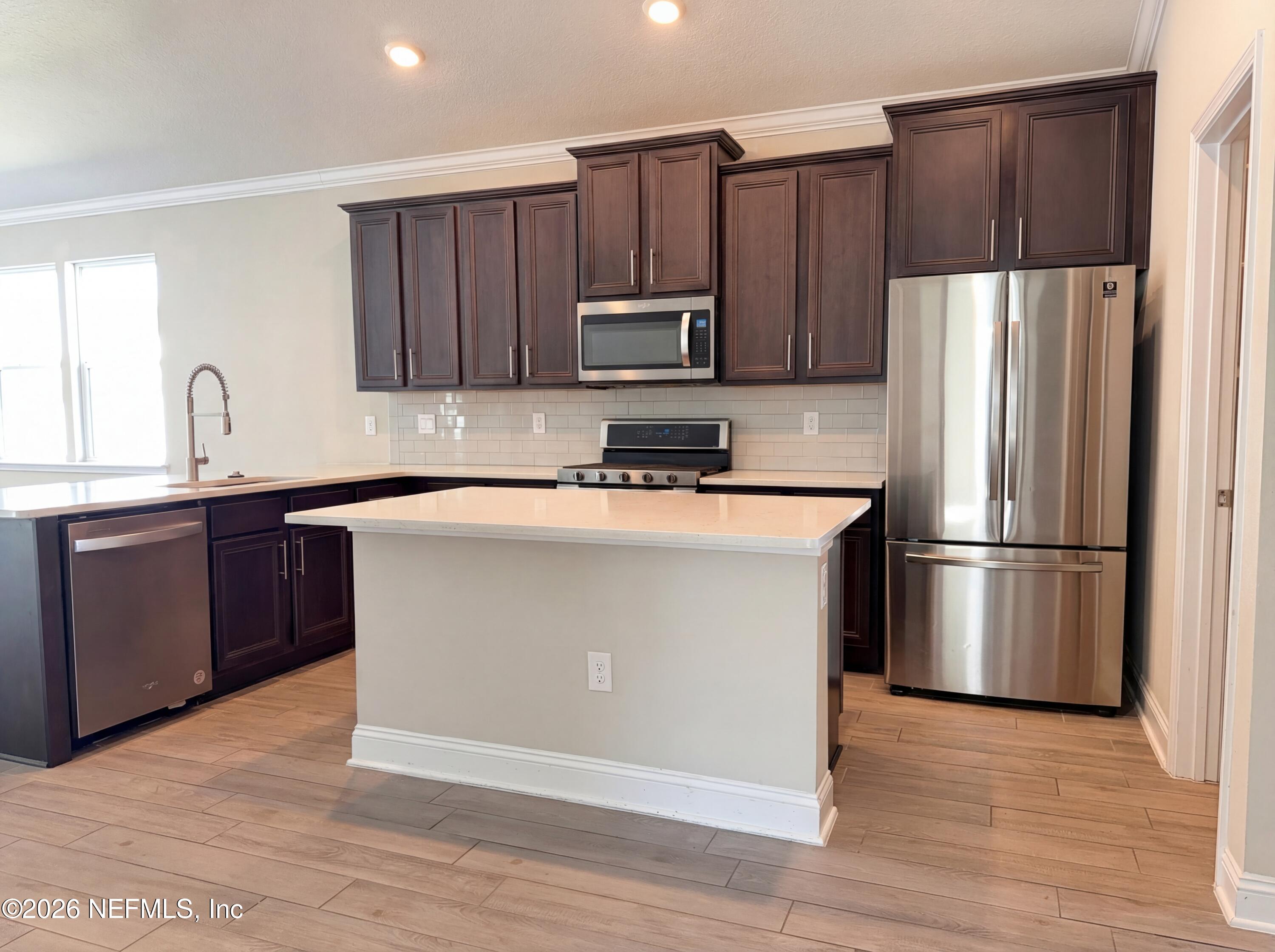 56 Thistleton Way Street St. Augustine, FL 32092 - Photo 2 of 28 a kitchen with kitchen island a sink stainless steel appliances and refrigerator