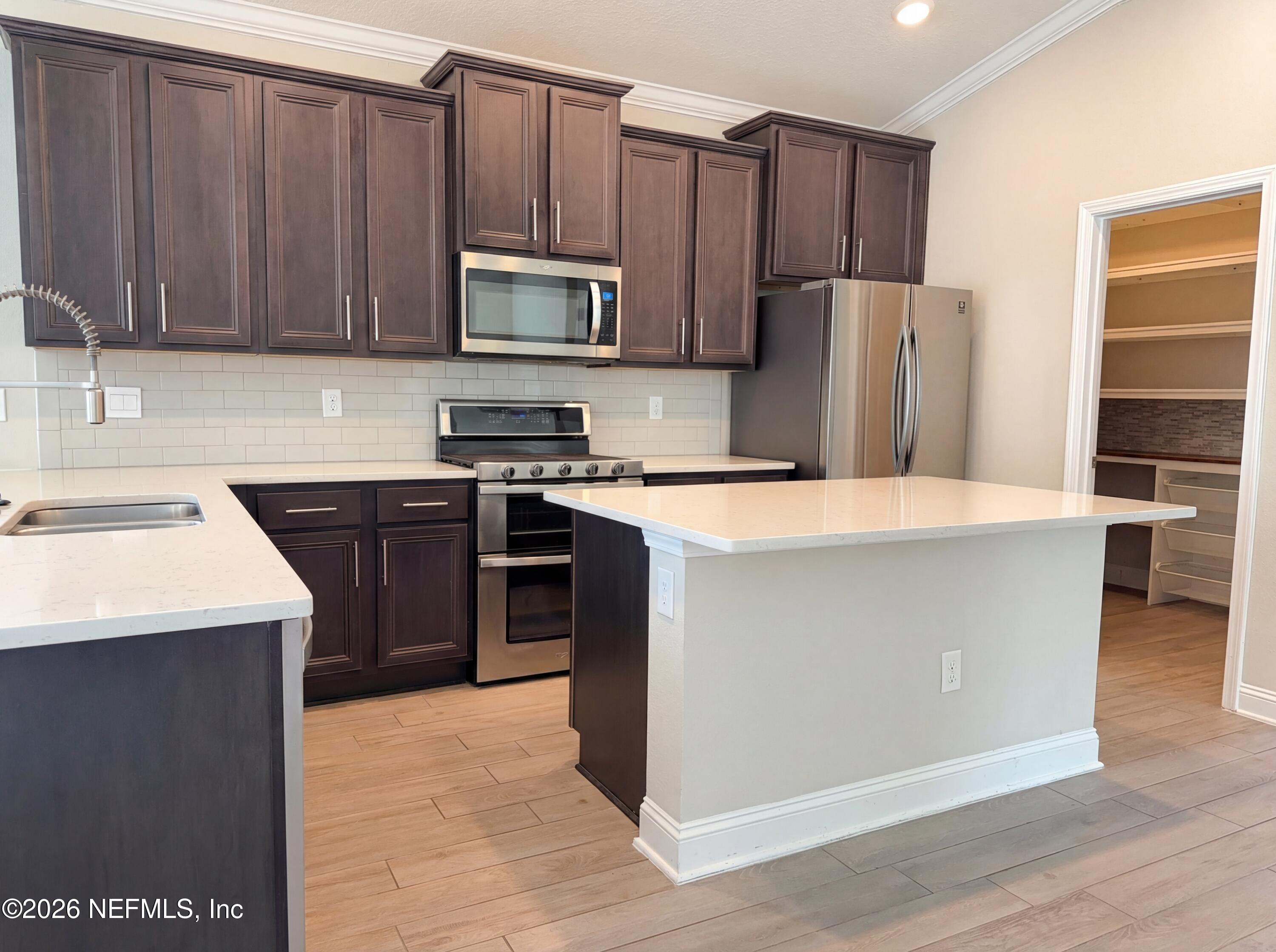 56 Thistleton Way Street St. Augustine, FL 32092 - Photo 10 of 28 a kitchen with stainless steel appliances a sink a stove a microwave and cabinetry