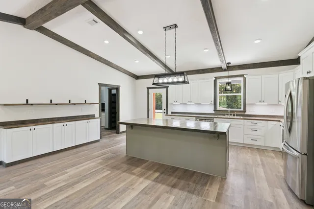 a large kitchen with stainless steel appliances kitchen island granite countertop a stove a sink and a refrigerator