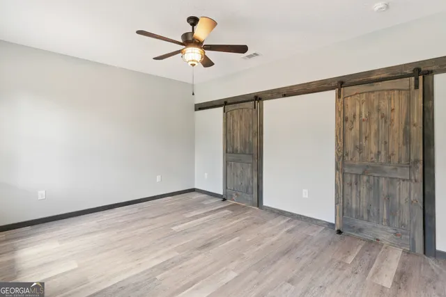 a view of an empty room with wooden floor