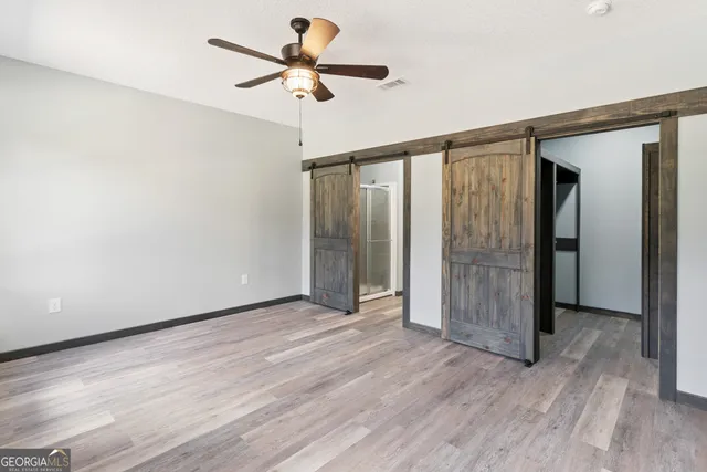 a view of an empty room with wooden floor