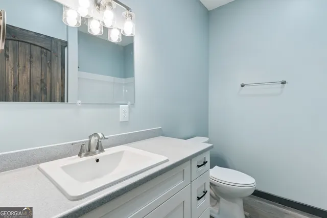 a bathroom with a sink a toilet and a mirror