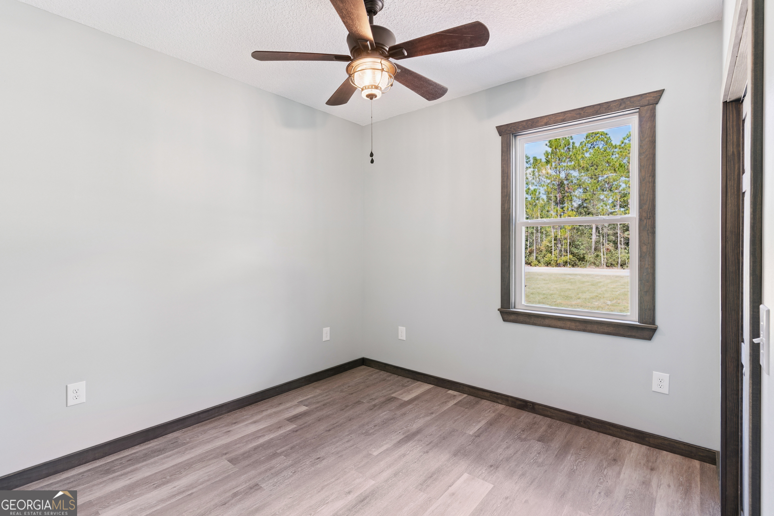 29 Chisholm Street Nahunta, GA 31553 - Photo 28 of 49 a view of an empty room with a window and wooden floor