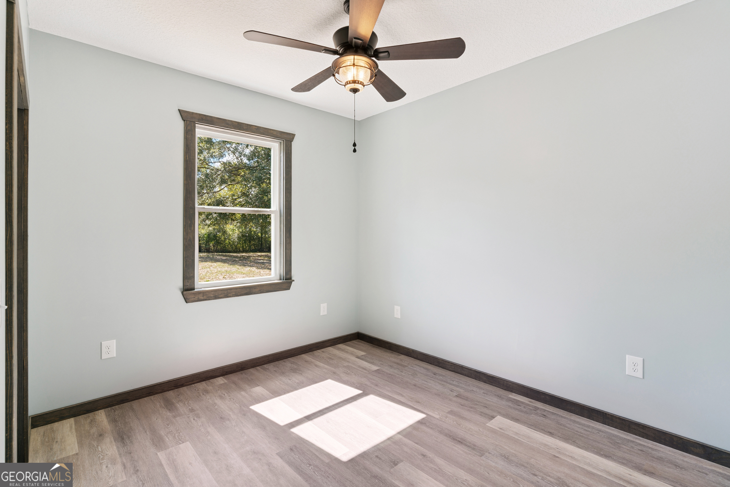 29 Chisholm Street Nahunta, GA 31553 - Photo 29 of 49 an empty room with a window and a ceiling fan