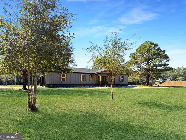 a view of a house with a yard and a tree