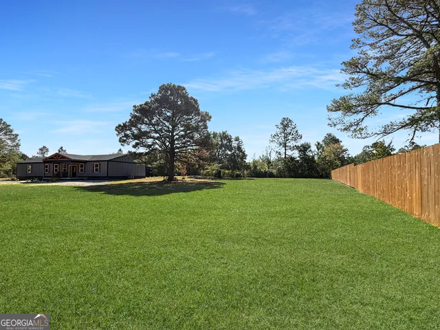 a view of a field of grass and trees