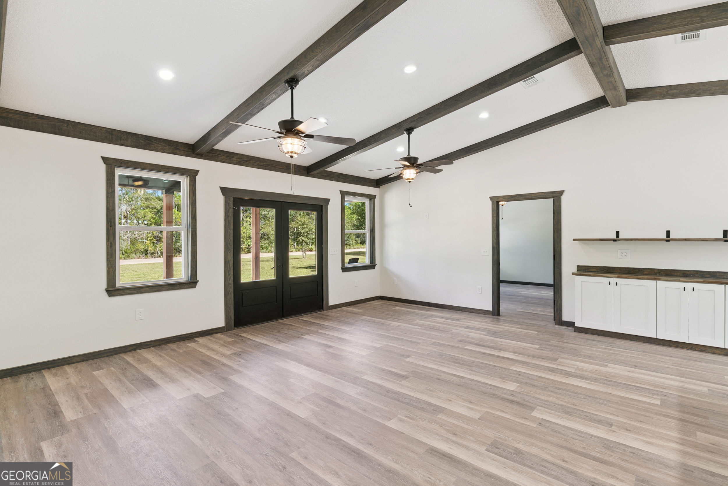 29 Chisholm Street Nahunta, GA 31553 - Photo 5 of 49 a view of an empty room with a window and wooden floor