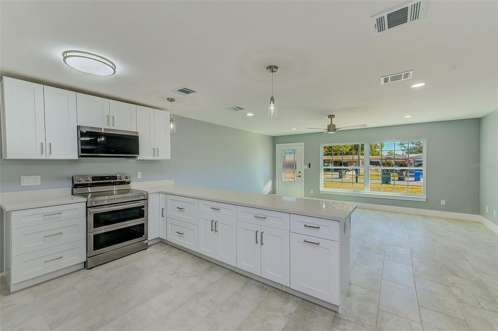 6208 Florida Circle East Apollo Beach, FL 33572 - Photo 12 of 43 a large white kitchen with white cabinets