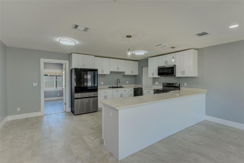 6208 Florida Circle East Apollo Beach, FL 33572 - Photo 9 of 43 a kitchen with refrigerator cabinets and microwave