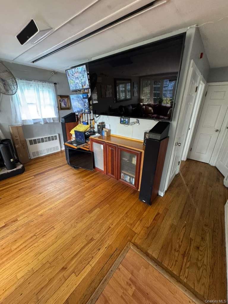 35 Harvard Street Valley Stream, NY 11580 - Photo 13 of 19 Bar featuring light wood-type flooring and radiator heating unit