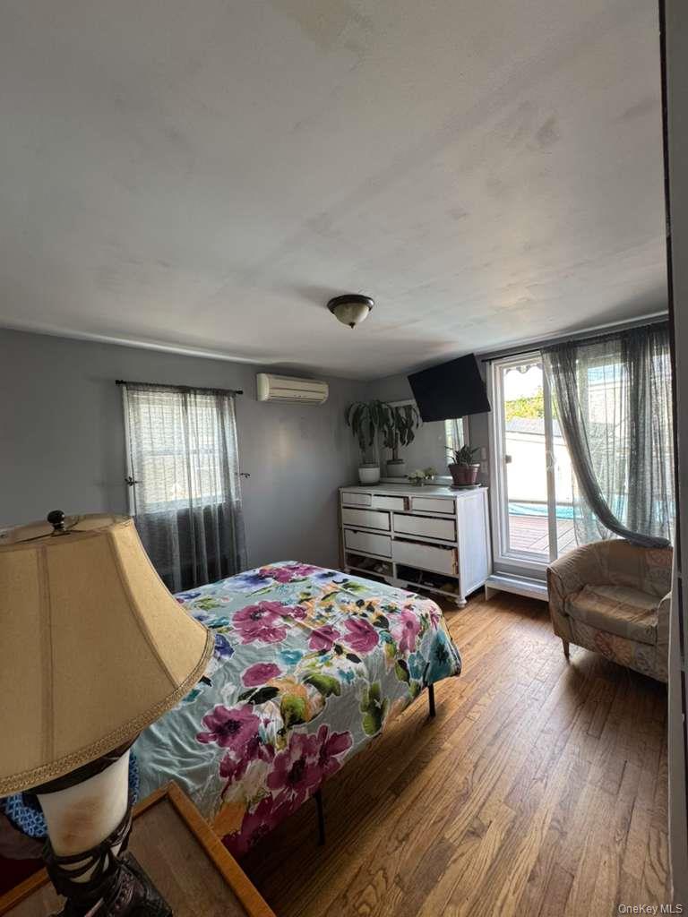 35 Harvard Street Valley Stream, NY 11580 - Photo 16 of 19 Bedroom featuring light wood-style floors, access to exterior, and an AC wall unit