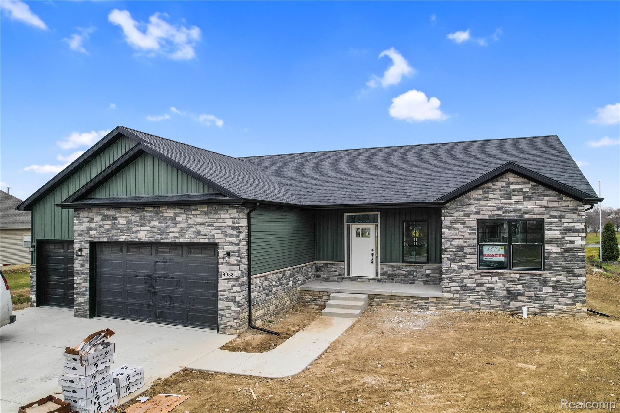 View of front of home with an attached garage, stone siding, a shingled roof, and concrete driveway