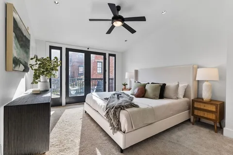 a bedroom with a large bed and a chandelier fan