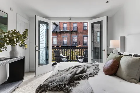 a bedroom with a large bed and a potted plant