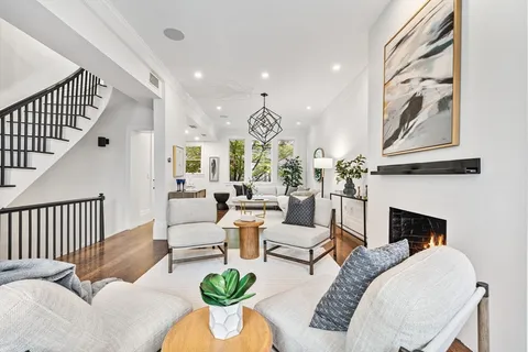 a living room with furniture a fireplace and a chandelier