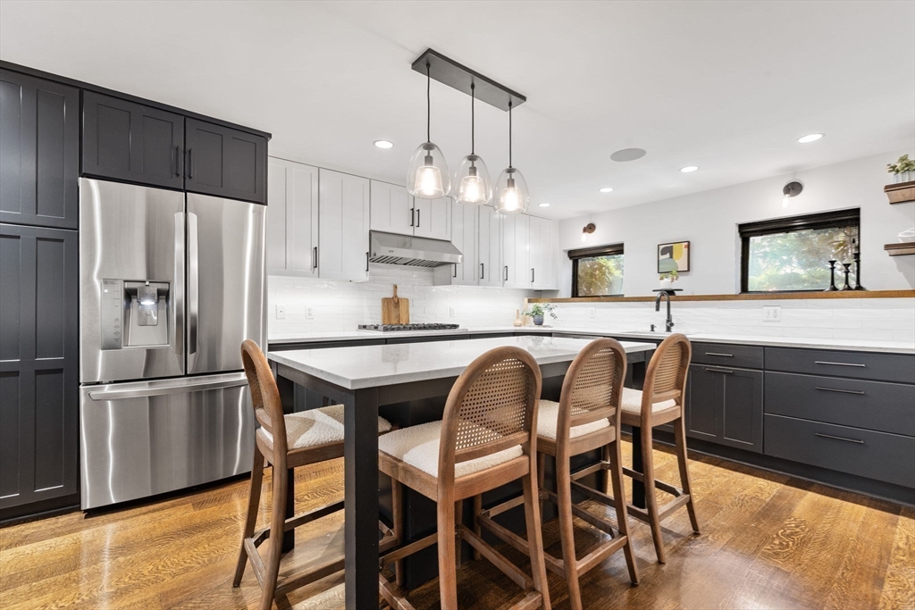 9 Bond Street Boston, MA 02118 - Photo 7 of 21 a kitchen with stainless steel appliances granite countertop a dining table chairs refrigerator and microwave