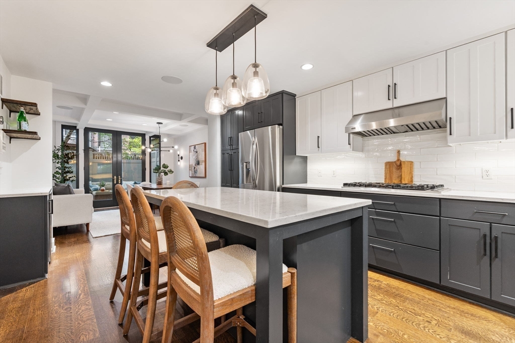 9 Bond Street Boston, MA 02118 - Photo 8 of 21 a kitchen with stainless steel appliances kitchen island granite countertop a table chairs sink and cabinets
