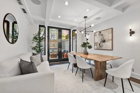 a living room with furniture a chandelier and a large window