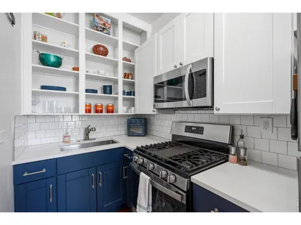 a kitchen with stainless steel appliances a sink stove and microwave