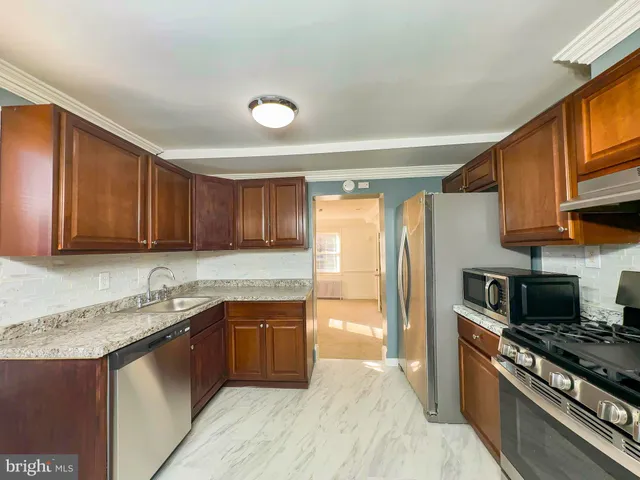 a kitchen with stainless steel appliances granite countertop a stove a sink and a microwave