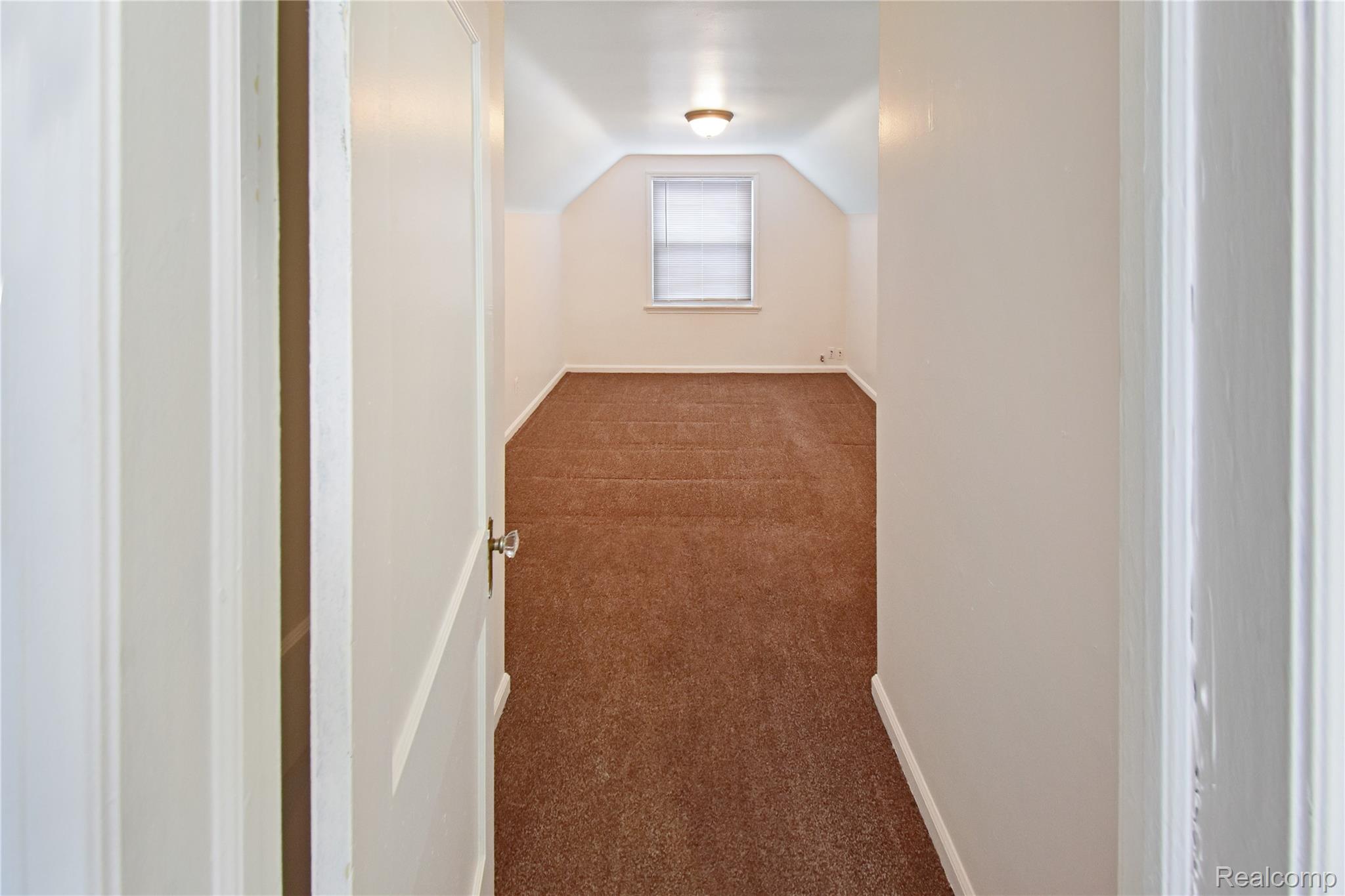 8305 Stephens Road Center Line, MI 48015 - Photo 13 of 23 Additional living space with dark colored carpet and lofted ceiling