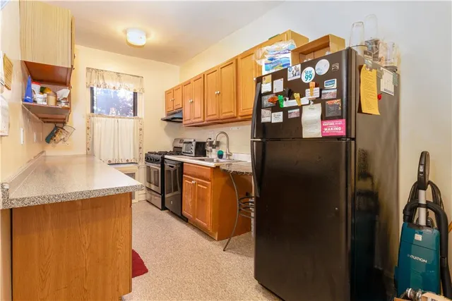 a kitchen with stainless steel appliances granite countertop a refrigerator a stove and a sink