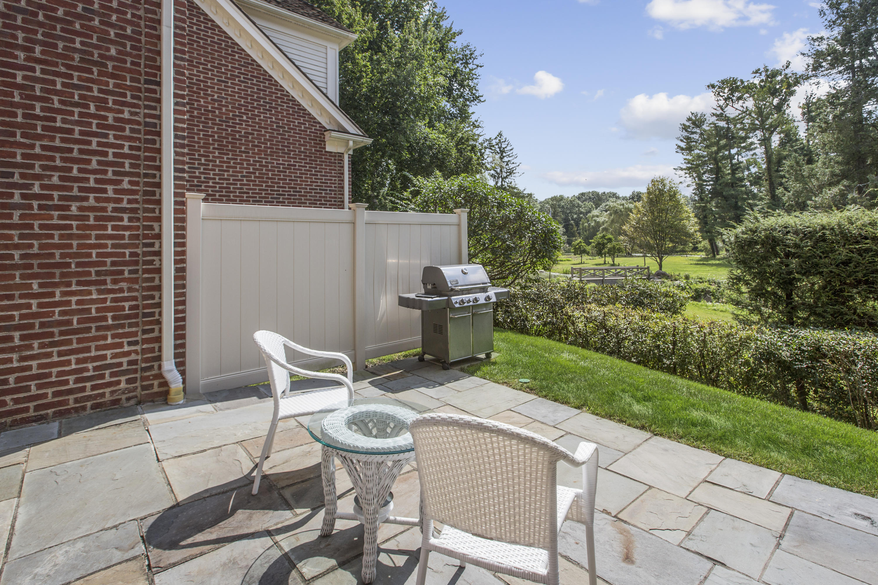 30 Richmond Hill Road, Unit 4 New Canaan, CT 06840 - Photo 33 of 40 a view of a chair and table in backyard of the house