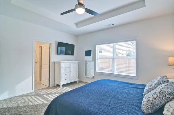 a spacious bedroom with a bed and a flat screen tv