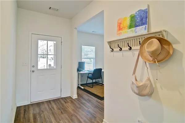 a view of a livingroom with wooden floor and a hallway