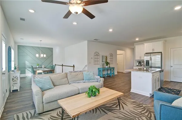 a living room with furniture kitchen view and a chandelier