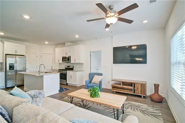 a living room with furniture kitchen view and a flat screen tv