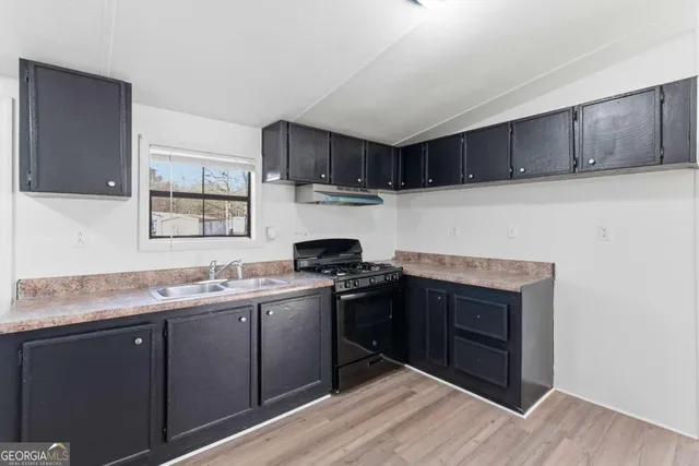 a kitchen with a sink stove and cabinets