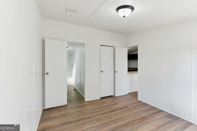 a view of an empty room with wooden floor