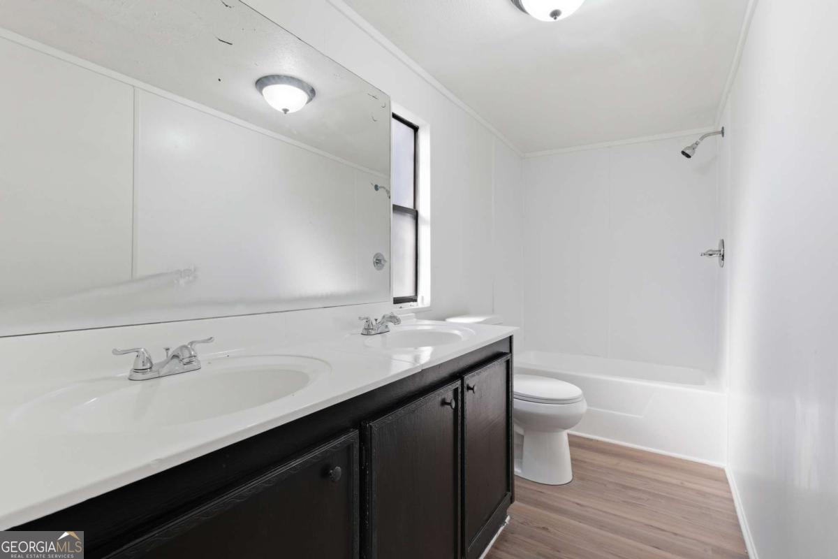 129 Rising Fawn Trail Northeast Rome, GA 30165 - Photo 15 of 25 a bathroom with a granite countertop sink a toilet and a large mirror