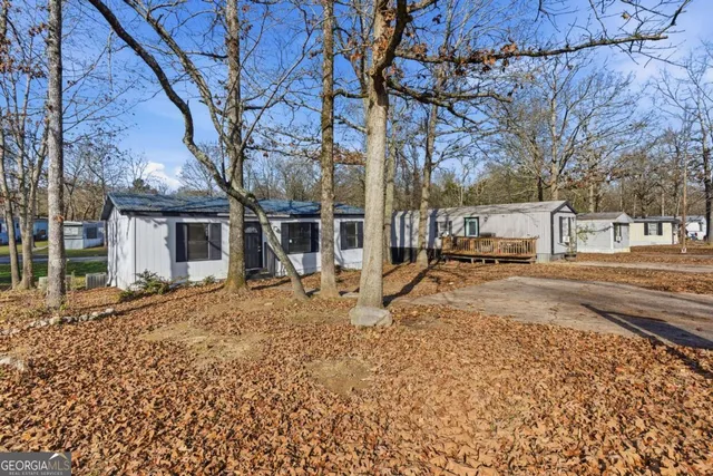 a view of a house with a yard and large tree
