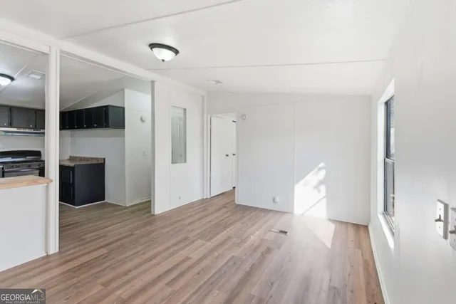 a view of empty room with wooden floor