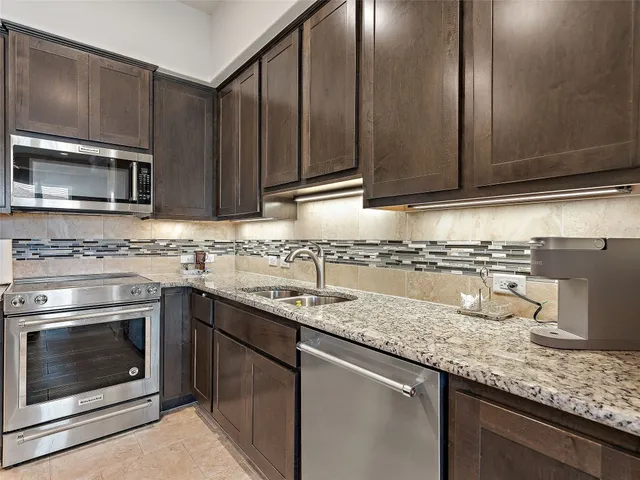 a kitchen with granite countertop cabinets stainless steel appliances and sink