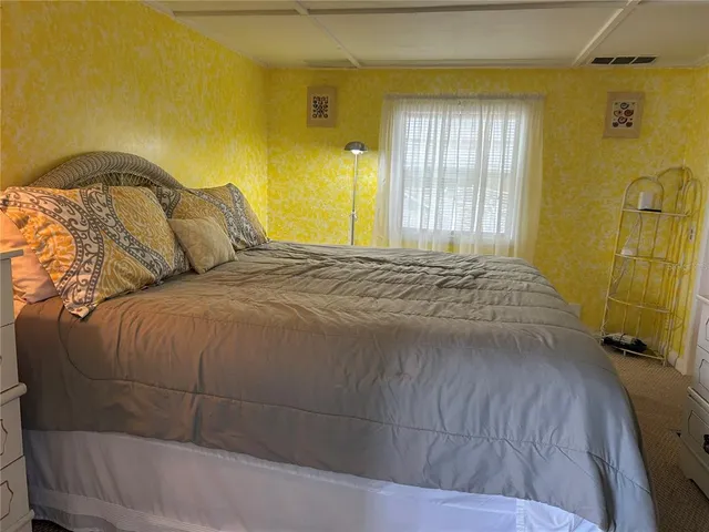 a bed sitting in a bedroom next to a window