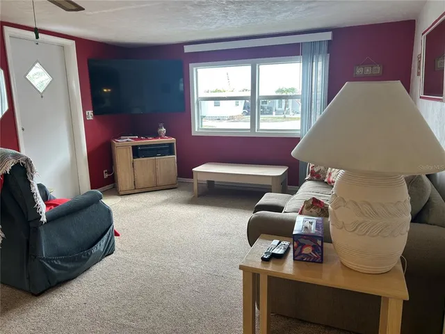 a living room with furniture a flat screen tv and a window