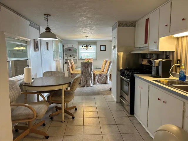 a kitchen with stainless steel appliances a dining table chairs and granite counter tops
