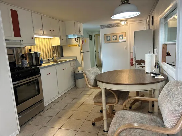 a kitchen with a table chairs sink and cabinets