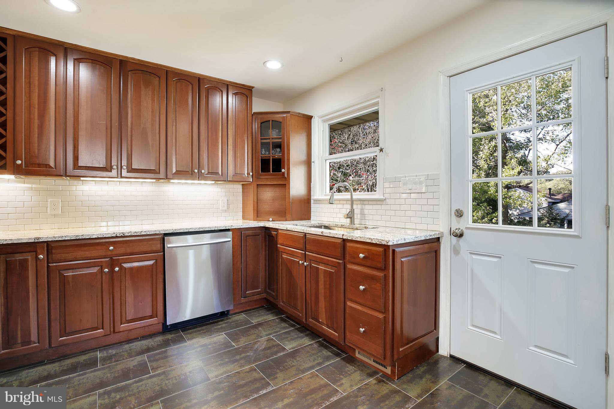 7422 Dunston Street Springfield, VA 22151 - Photo 11 of 30 a kitchen with stainless steel appliances granite countertop wooden cabinets a sink and a window