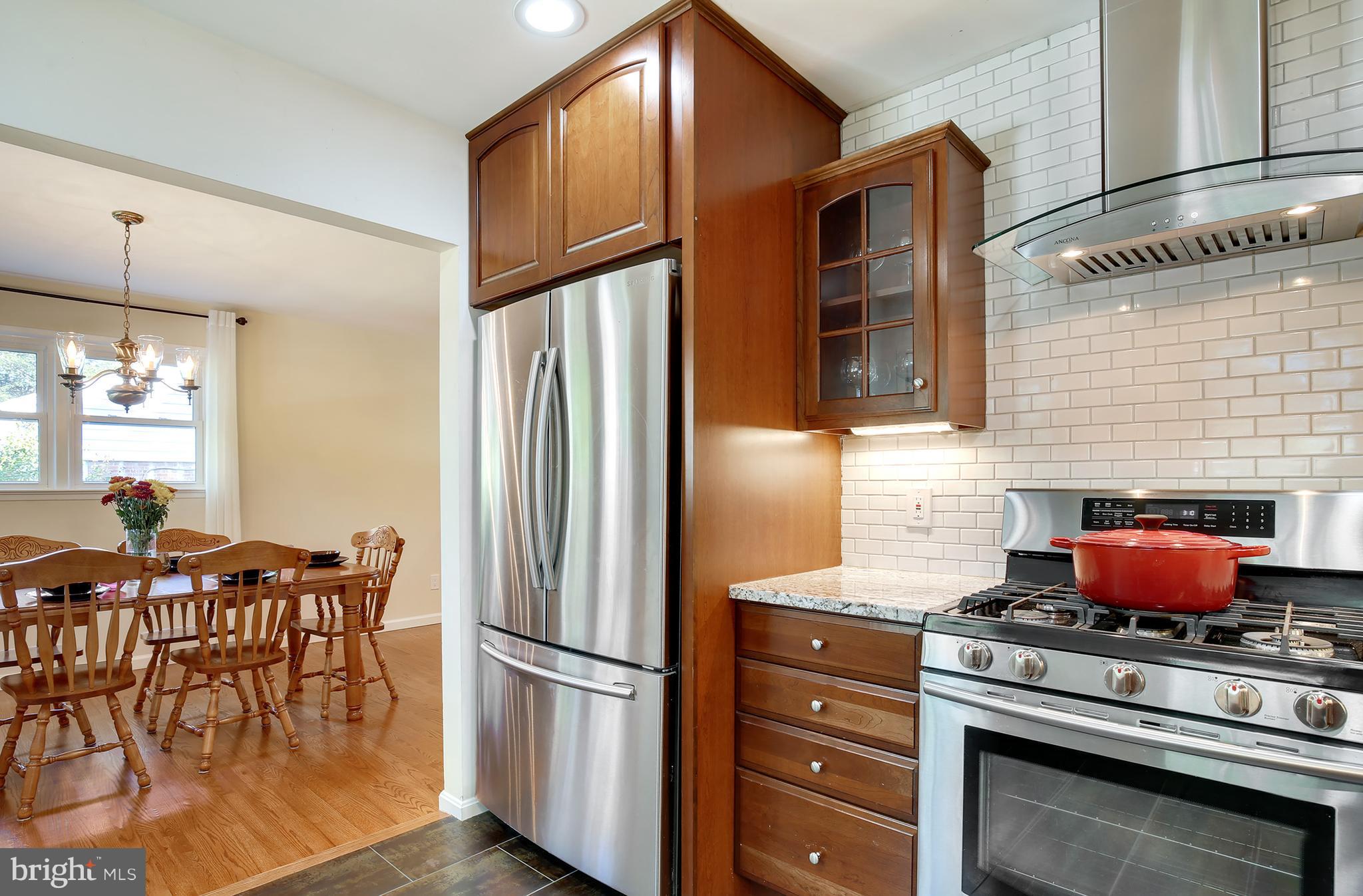 7422 Dunston Street Springfield, VA 22151 - Photo 13 of 30 a kitchen with stainless steel appliances granite countertop a stove and a refrigerator