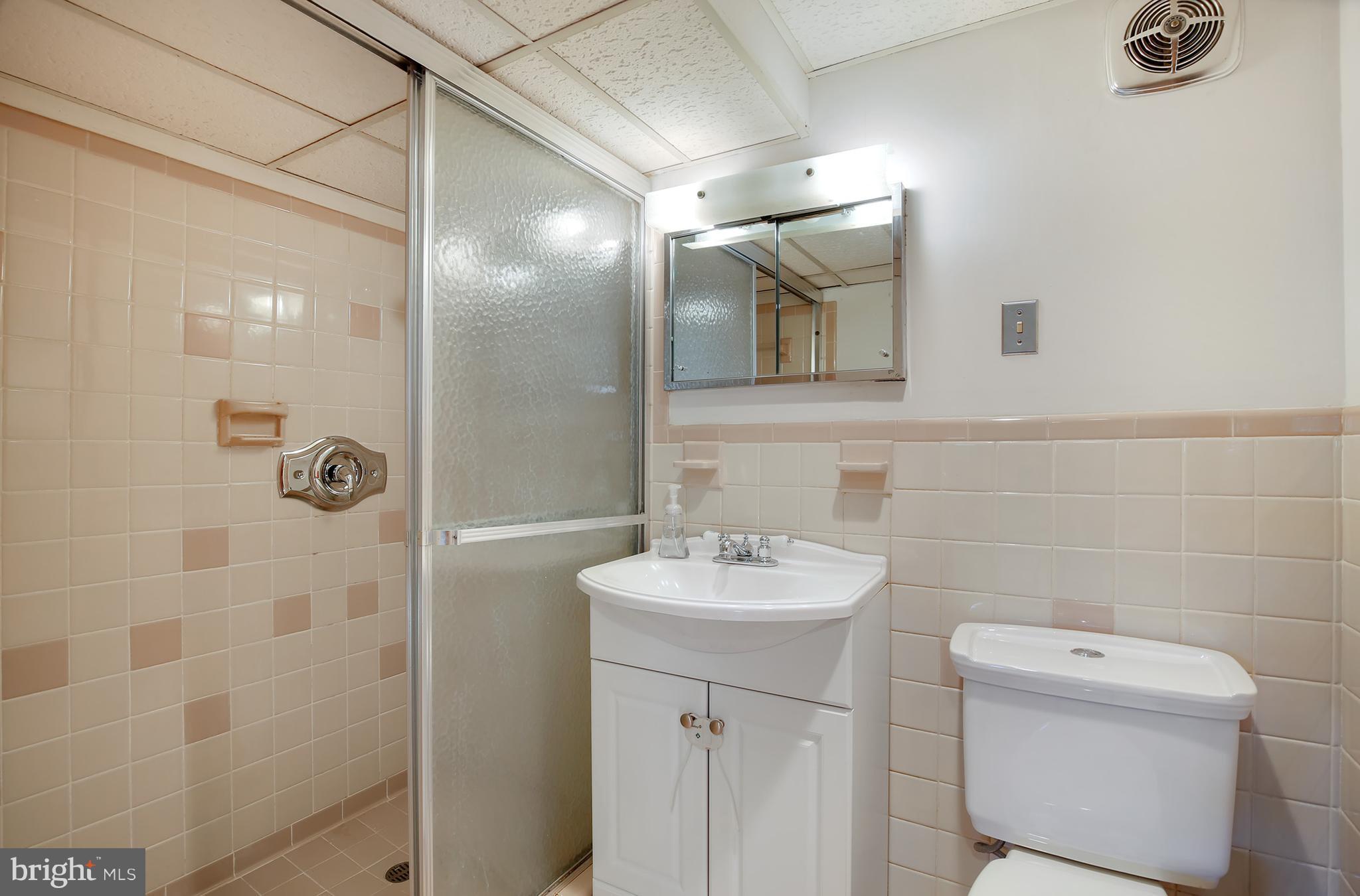 7422 Dunston Street Springfield, VA 22151 - Photo 27 of 30 a bathroom with a sink a toilet and shower