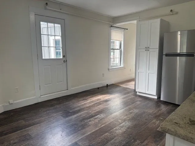 an empty room with wooden floor and a window