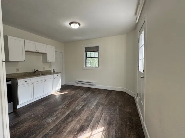 a view of a room with wooden floor and white walls