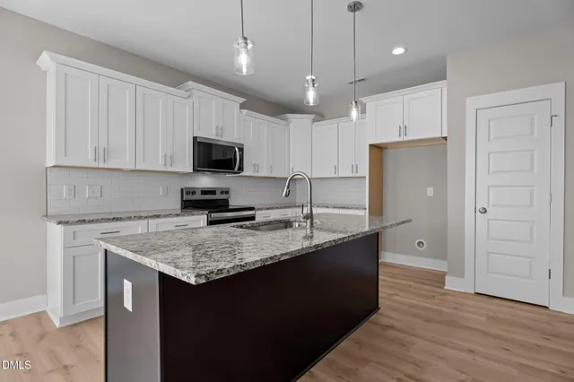 a bathroom with a granite countertop sink two mirror and shower