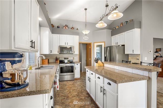 a kitchen with stainless steel appliances granite countertop a stove oven and a refrigerator